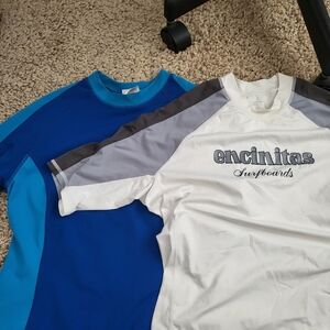 Two short-sleeved rash guards or swim cover-ups in size M.